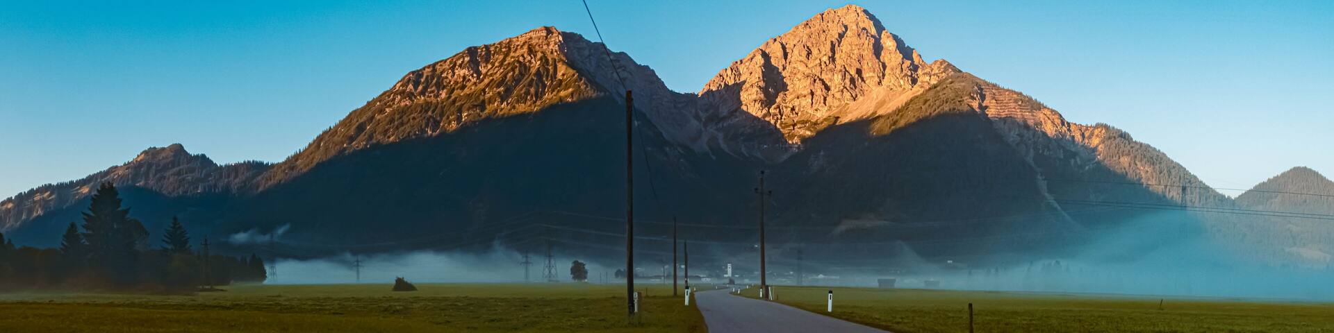 High resolution stitched panorama of a beautiful alpine foggy sunrise view at the famous Heiterwanger See lake near Bichlbach, Tyrol, Austria