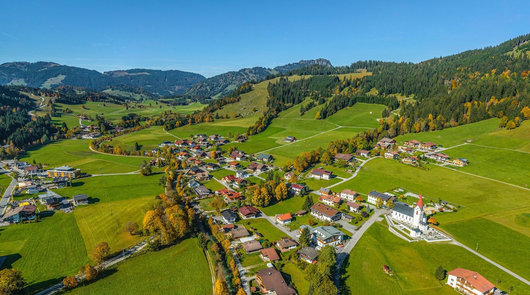 A rural village nestled in a valley with houses, roads, and surrounding hills.