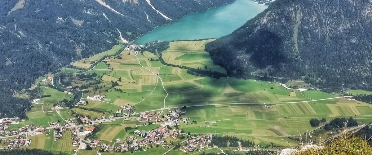 A mountainous landscape with a lake and a village.