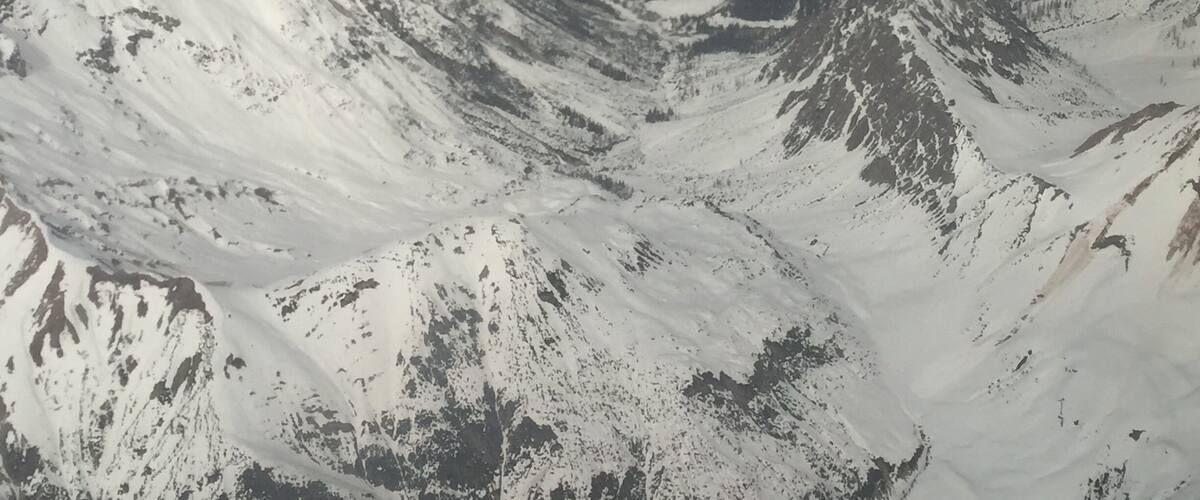 A snow-covered mountain range with rugged peaks and valleys.