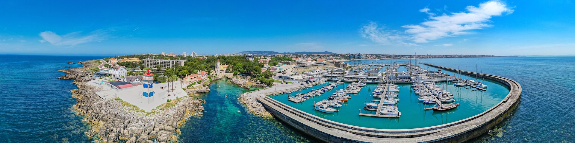Cascais, Portugal - Aerial view of the Portuguese coastline, marina, beaches and villas of Cascais during heatwave in summer