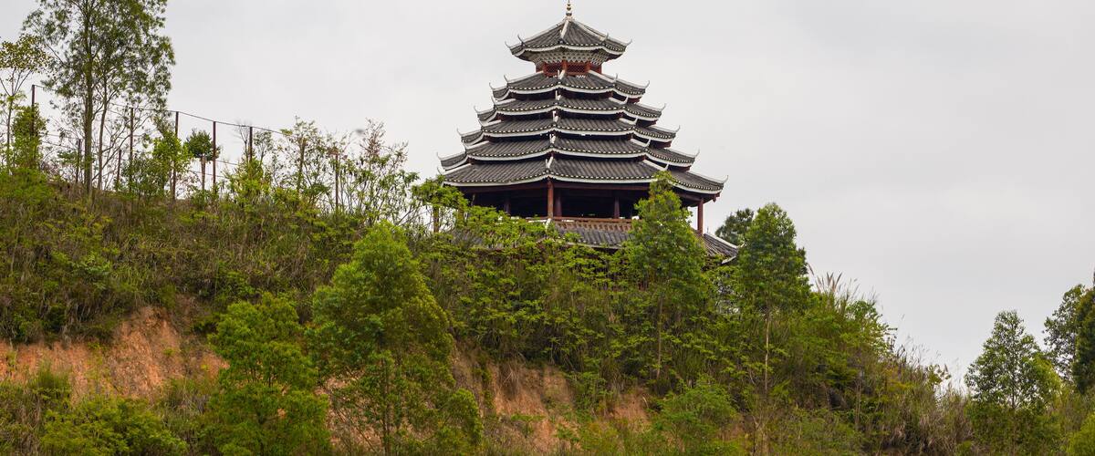A traditional multi-tiered pagoda surrounded by lush greenery and trees.