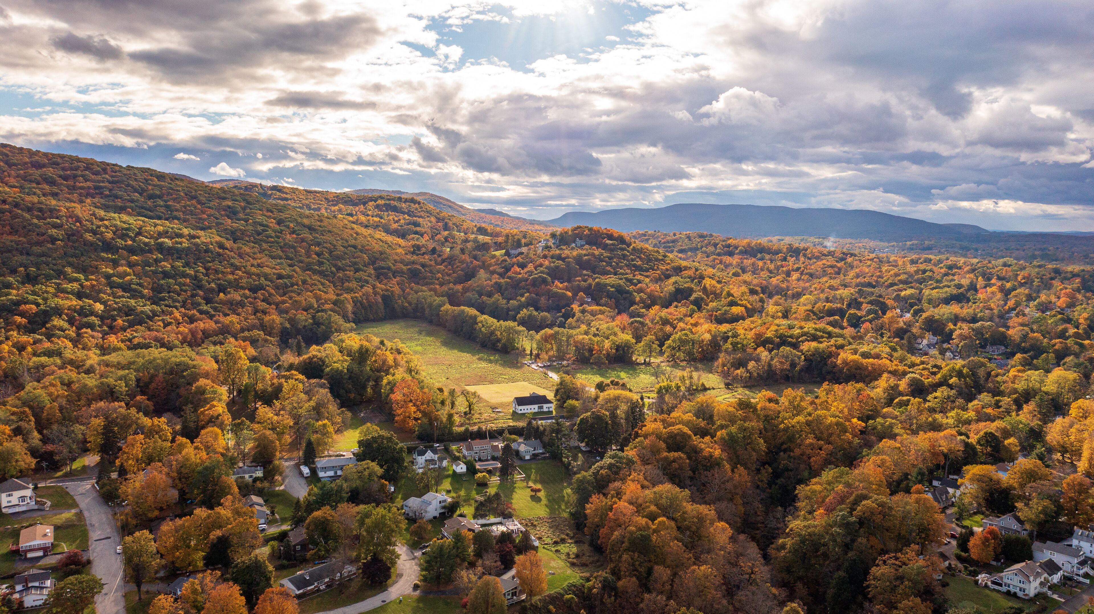 Aerial view of vibrant autumnal foliage covering a mountain in Cornwall-on-Hudson, New York