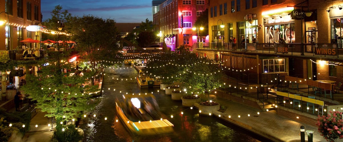 Bricktown showing a city, a river or creek and night scenes