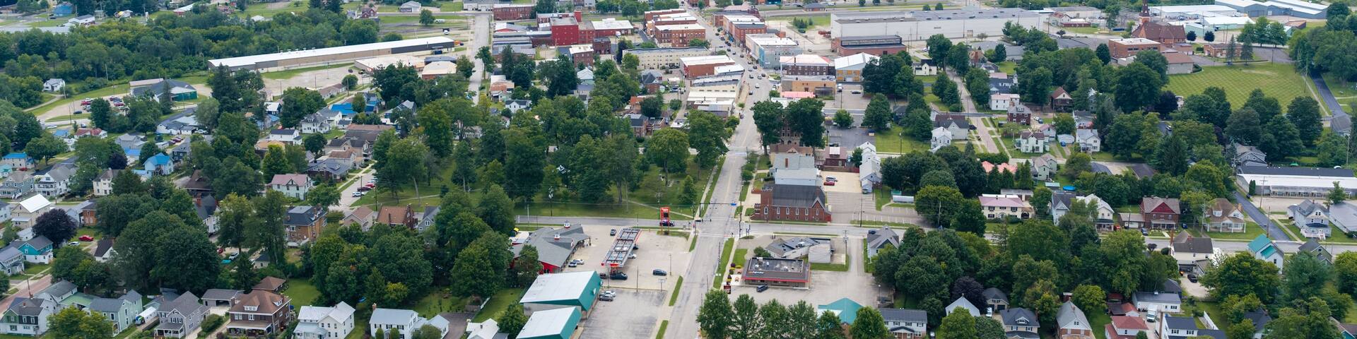 A suburban area with a mix of residential houses, commercial buildings, and a large industrial facility.