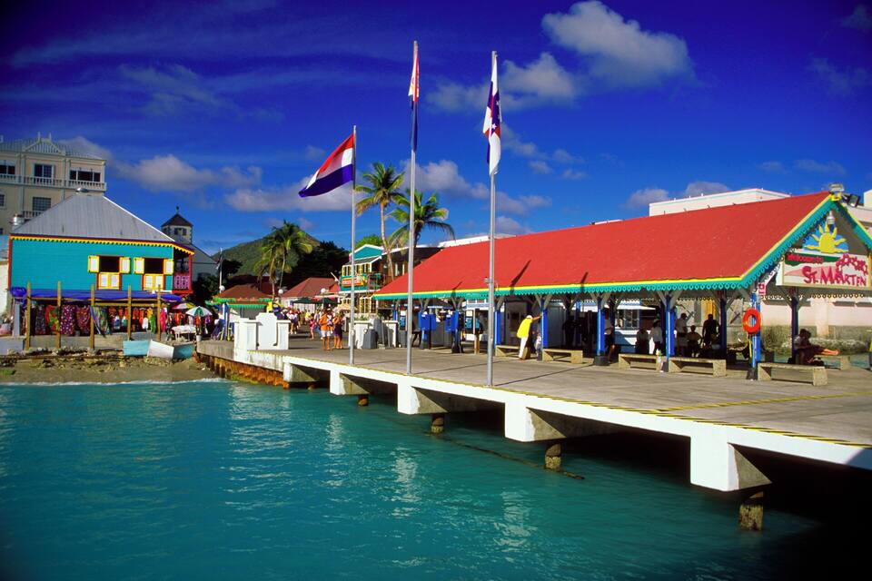 A pier with a red roof, flags, and a sign for 'S&Martin'.