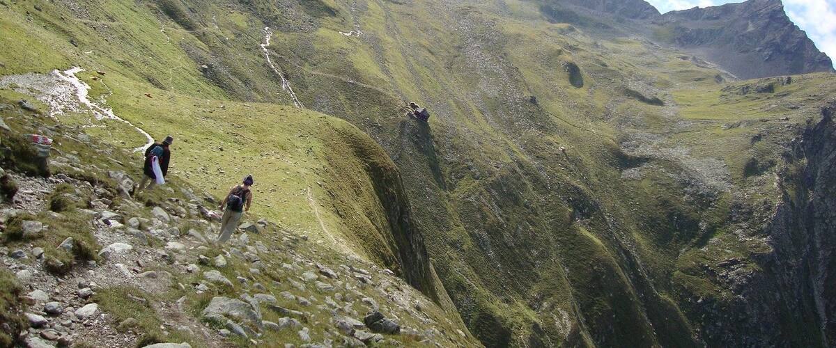 A mountainous landscape with hikers on a trail.