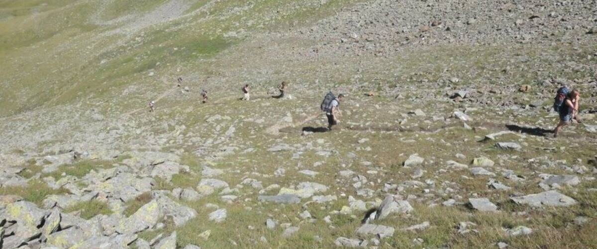 A rocky mountain landscape with hikers.
