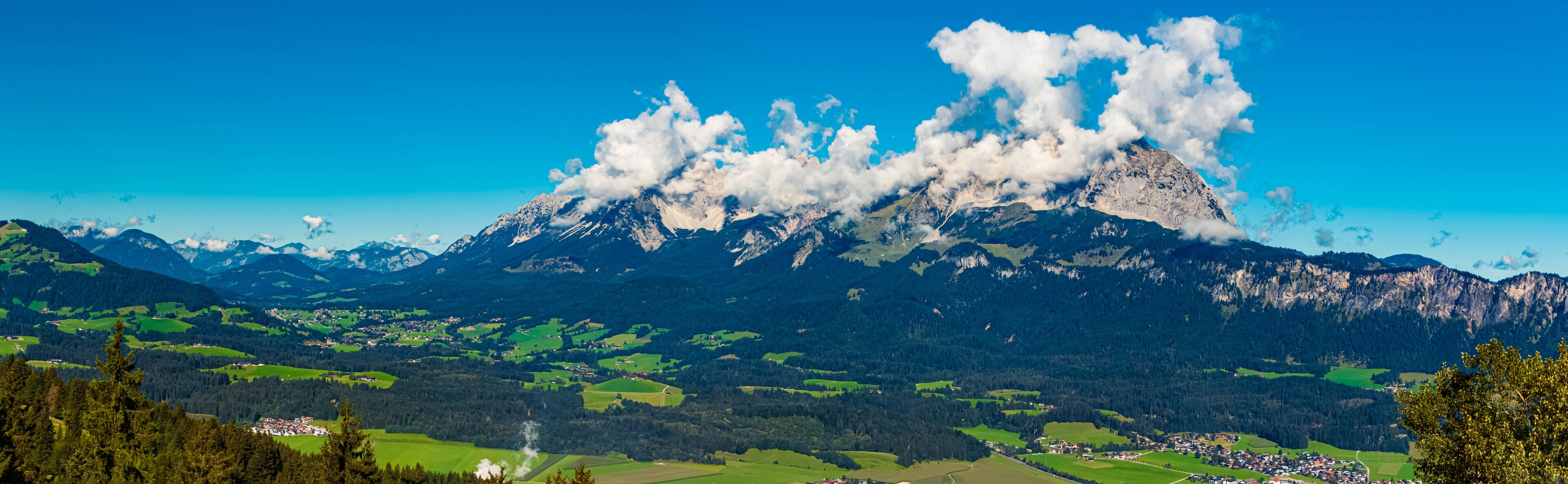 Alpine summer view with Mount Wilder Kaiser covered in clouds seen from Mount Harschbichl, Sankt Johann in Tirol, Kitzbuehel, Tyrol, Austria