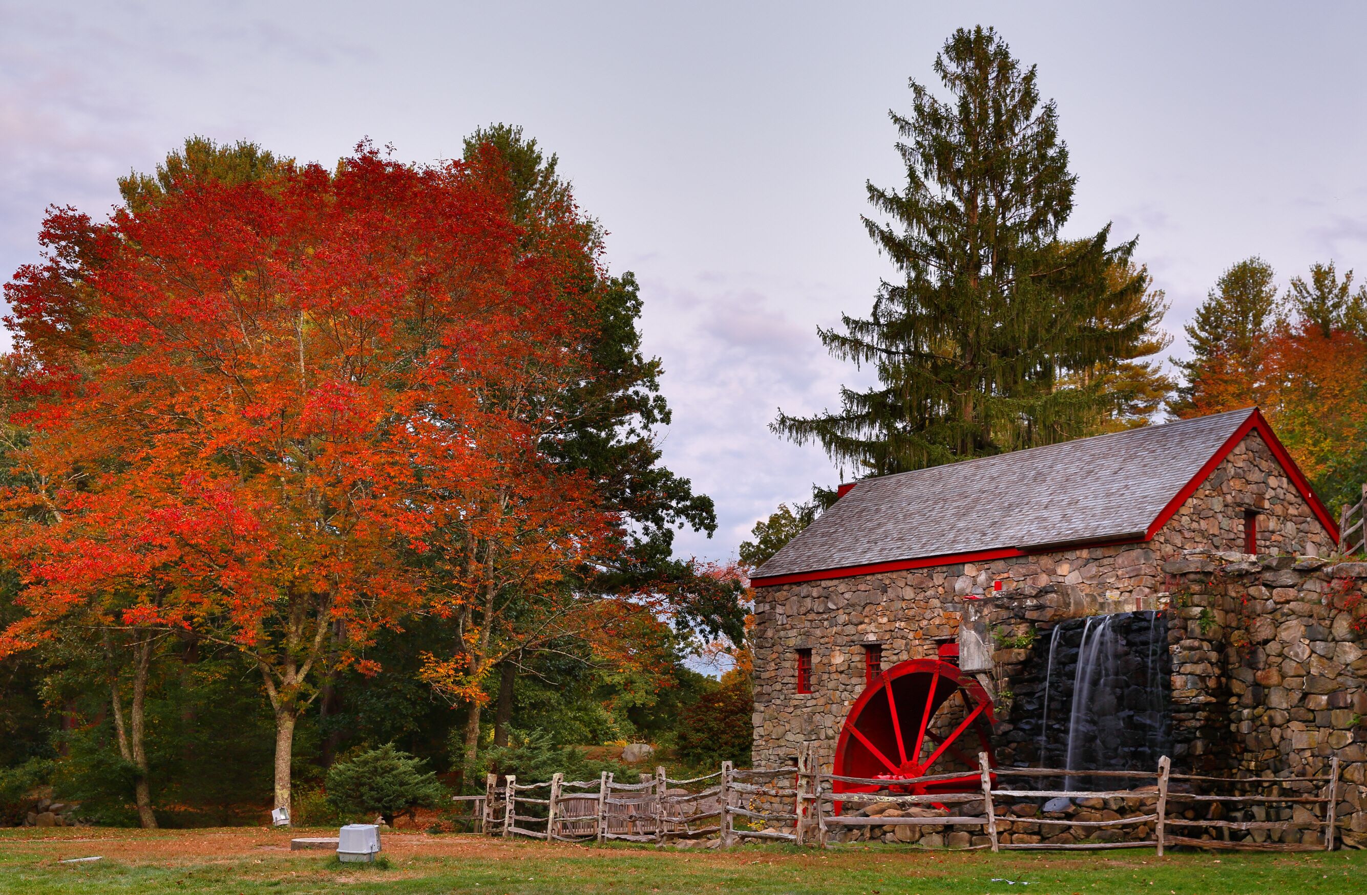The Wayside Inn Grist Mill with water wheel and cascade water fall in Autumn. 