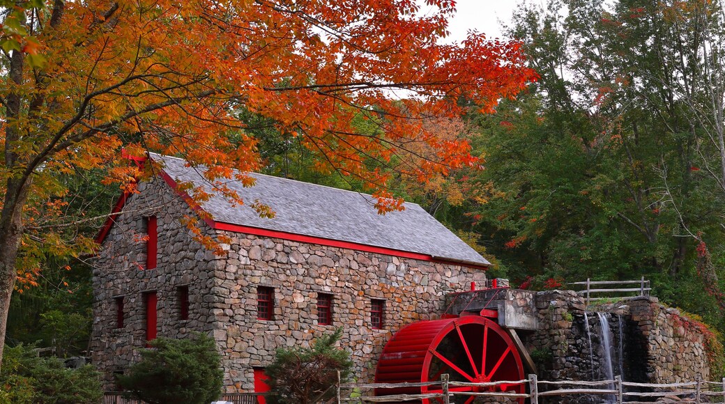 The Wayside Inn Grist Mill with water wheel and cascade water fall in Autumn.
