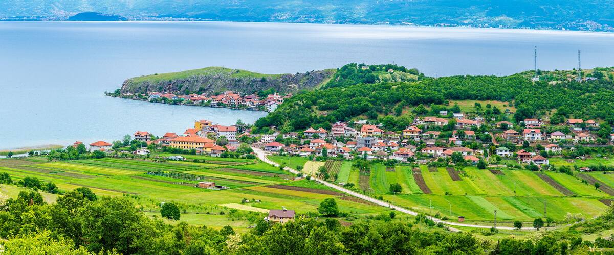 A coastal village with terraced fields and a lake.