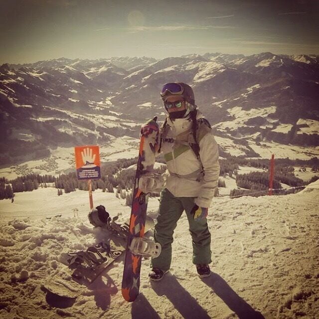A person with skis standing on a snowy mountain slope.