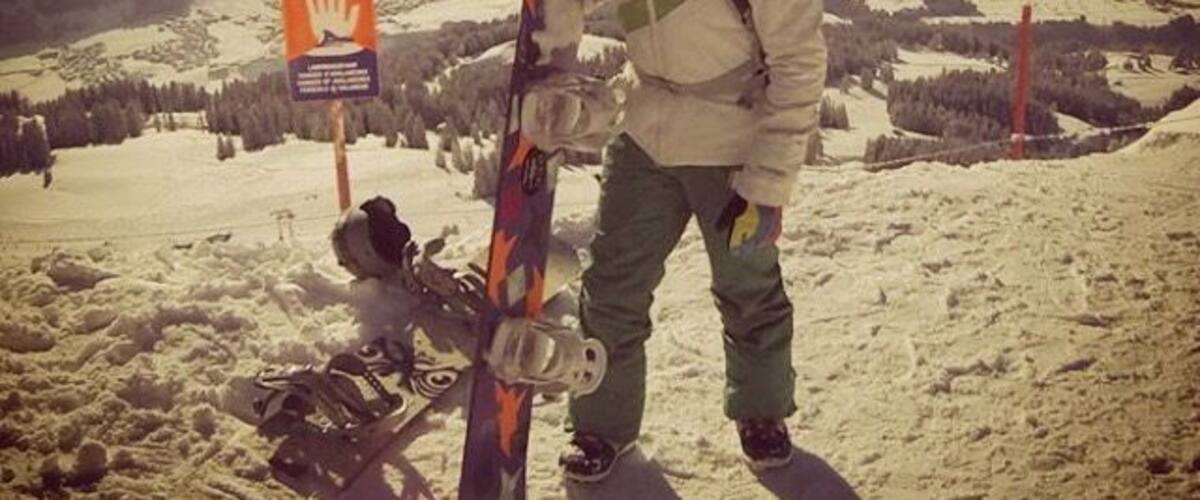 A person with skis standing on a snowy mountain slope.