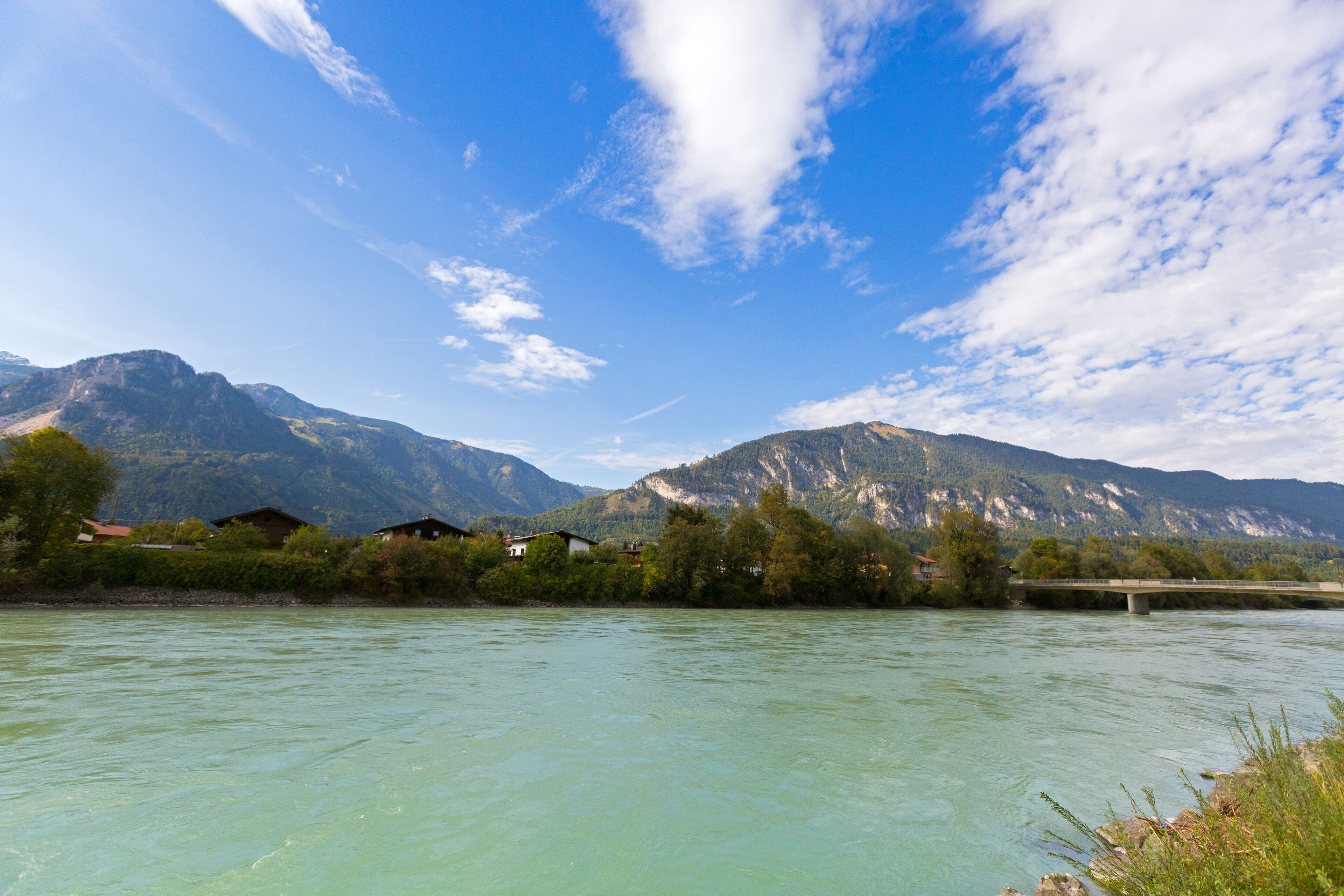 Inn river with big mountain, blue sky in background, in Rattenberg, Tyrol in Austria, Europe