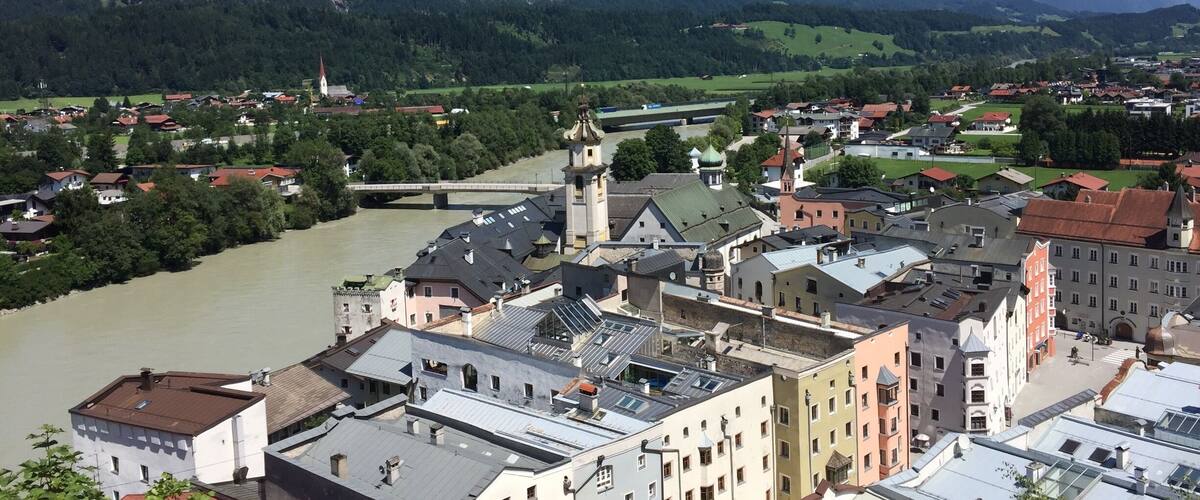 A town with a river, mountains, and a bridge.