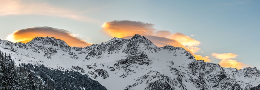 A snow-covered mountain range with a sunset.