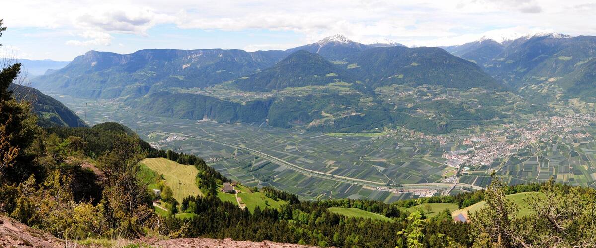 A mountainous landscape with a valley, fields, and a small town.