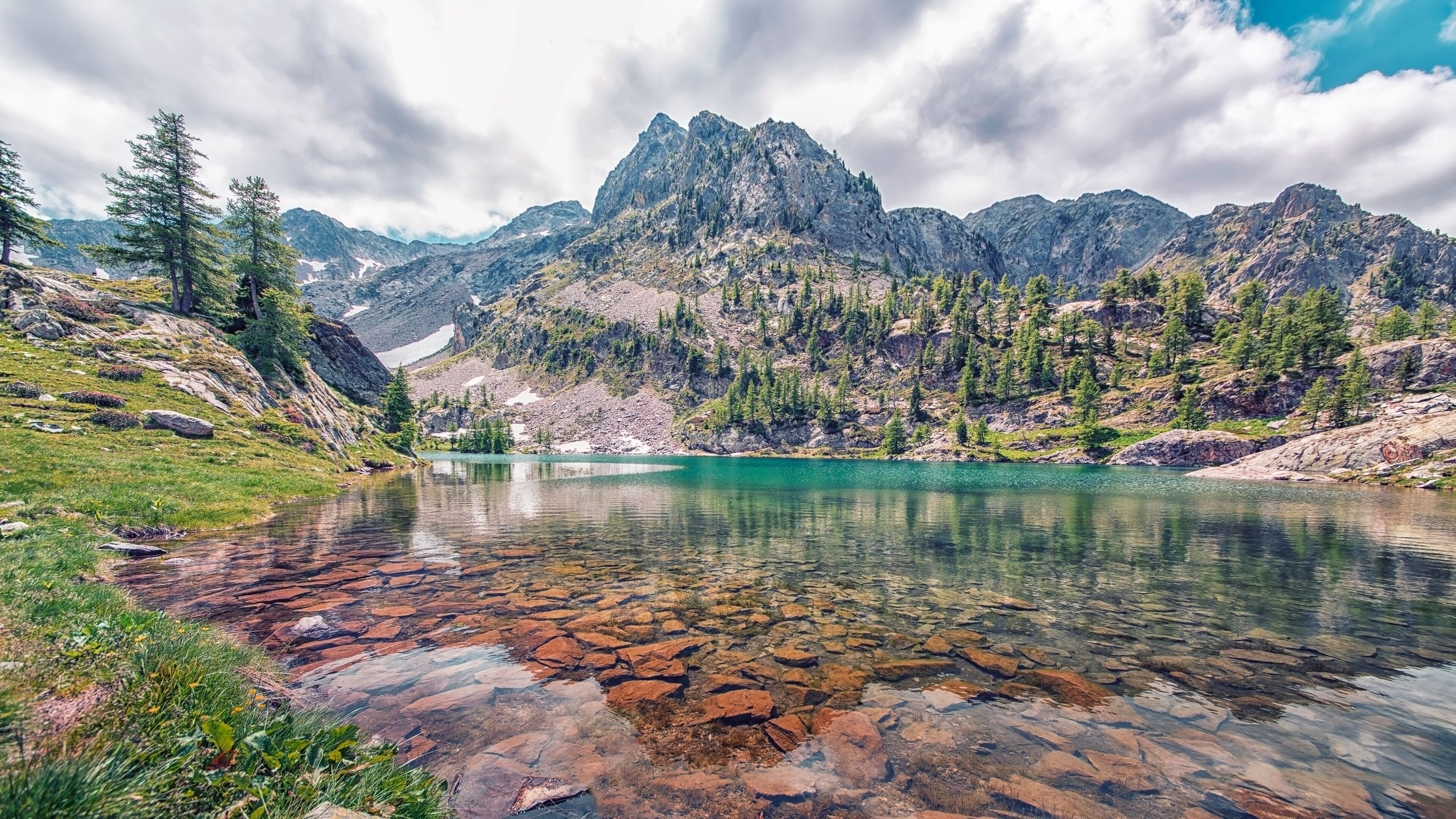 A mountain lake surrounded by rocky terrain and sparse vegetation.