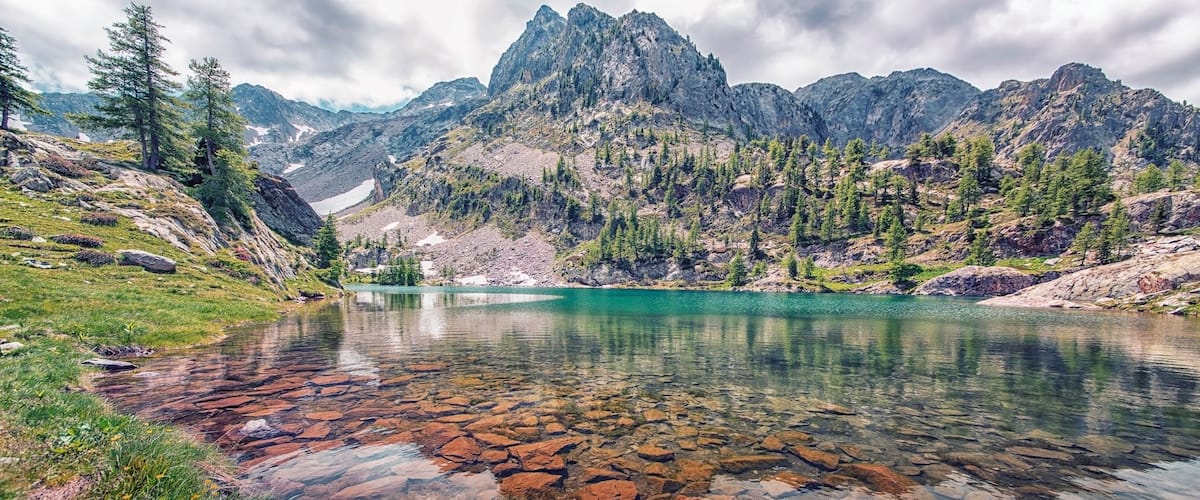 A mountain lake surrounded by rocky terrain and sparse vegetation.