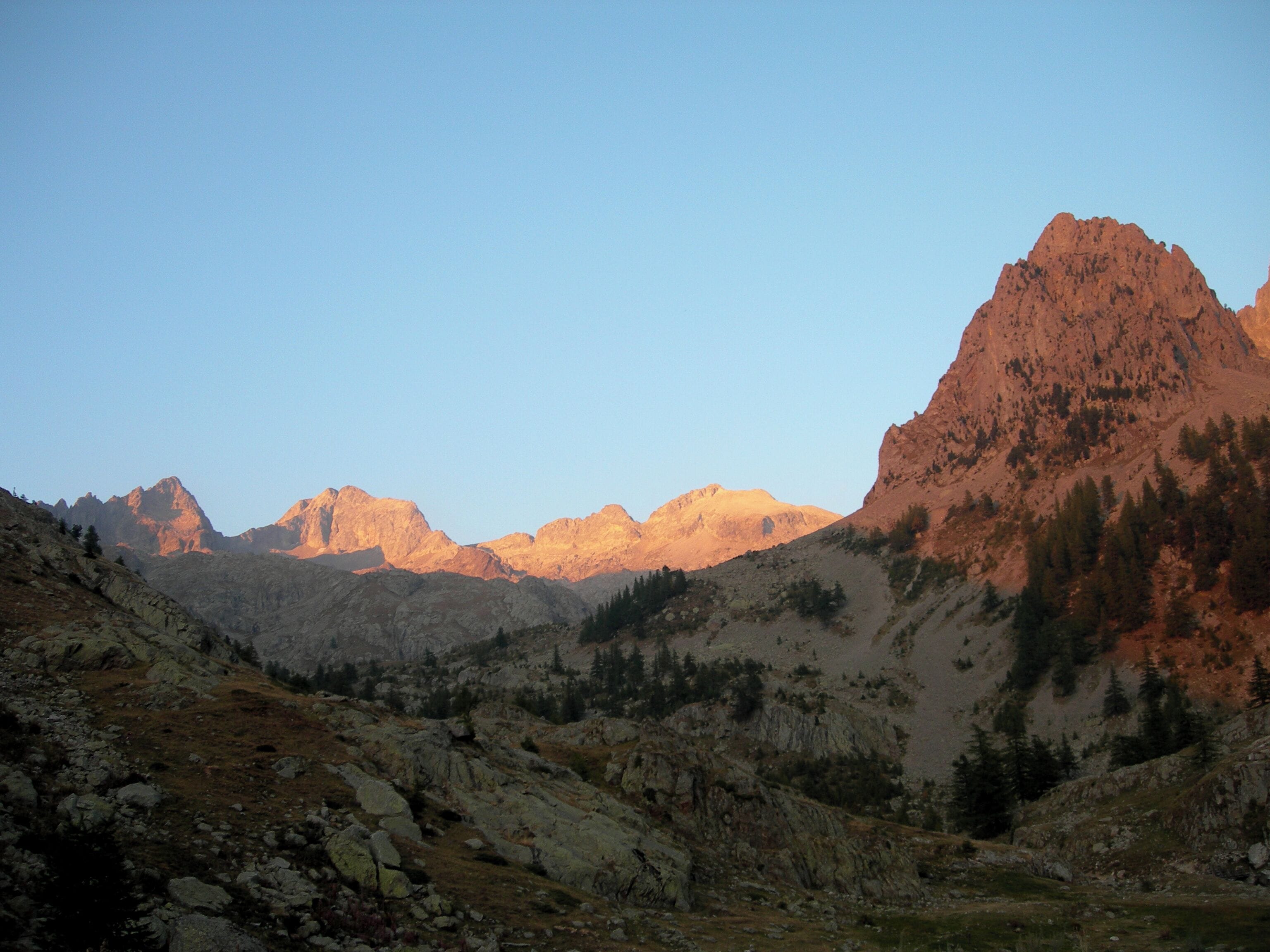 A mountainous landscape with rocky terrain and sparse vegetation.