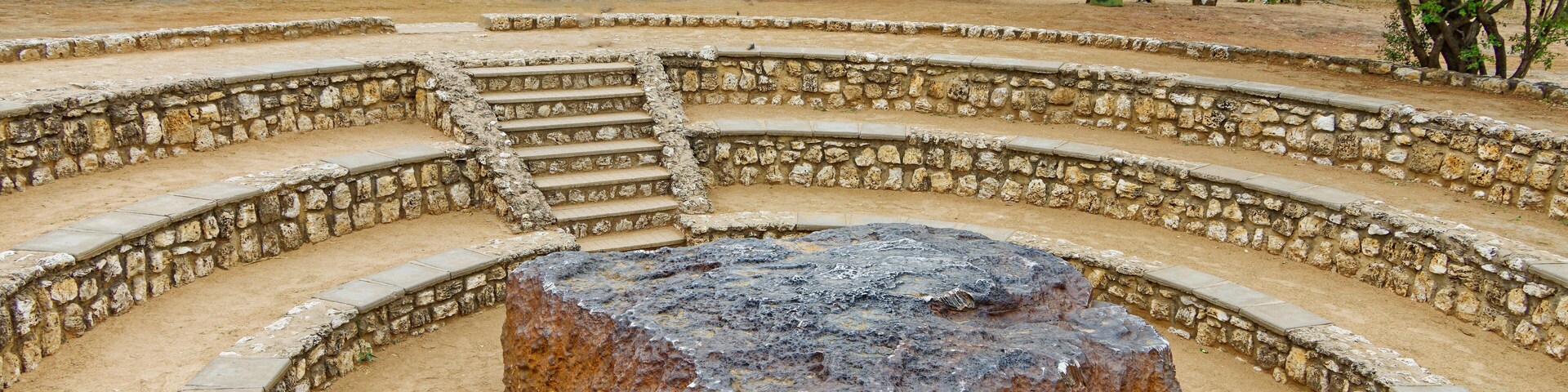 A stone amphitheater with a central rock.