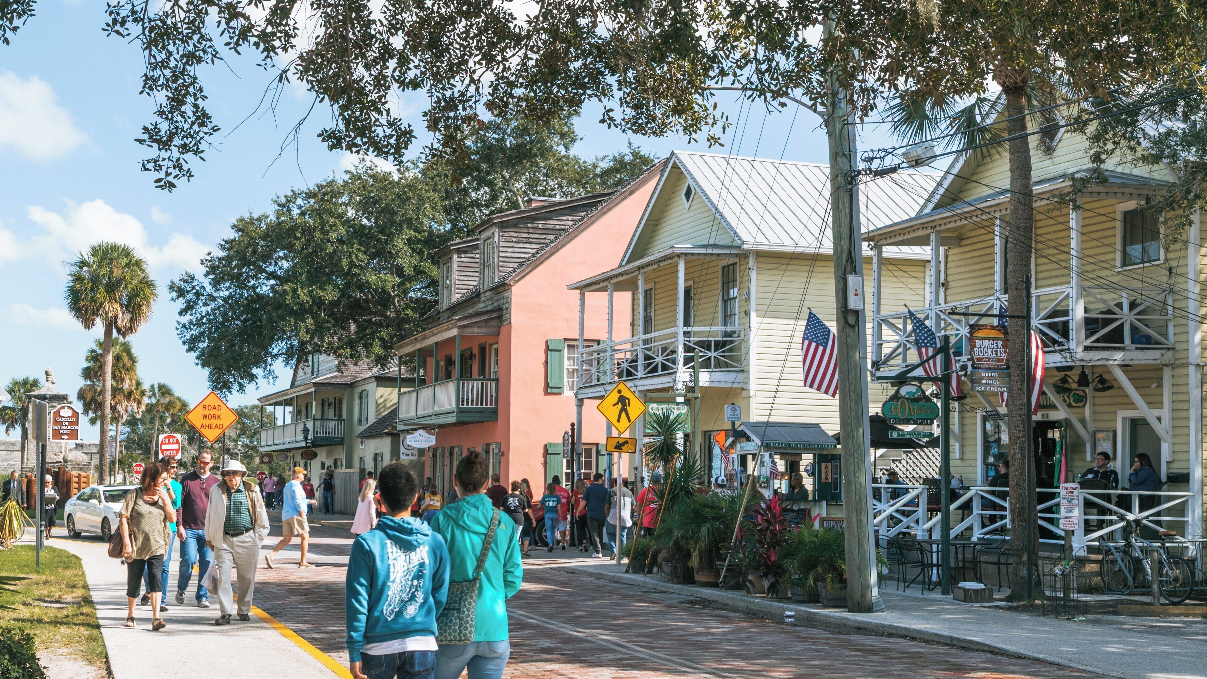 Colorful buildings line St. George Street in the historic district of St. Augustine, Florida, filled with people enjoying a sunny day