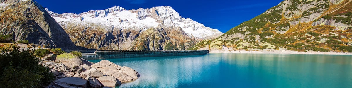 A mountain lake with a dam and rocky shores.