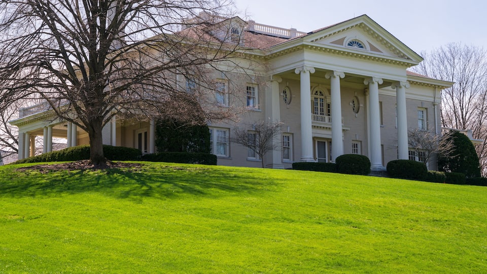 A large, stately building with a symmetrical facade, columns, and a central pediment.