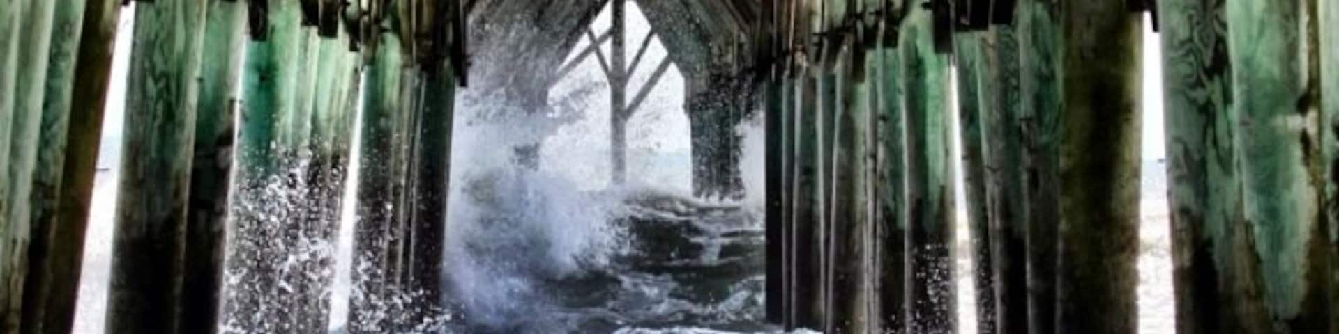 A wooden pier with waves crashing underneath.