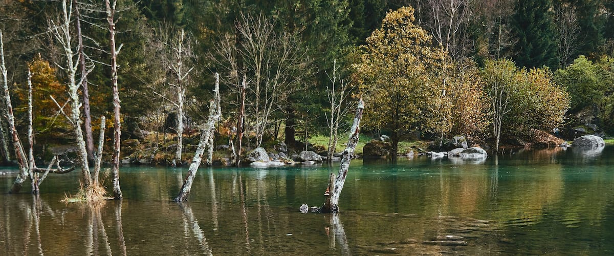 panorama view of small lake with reflections and multicolor woods, in autumn season lake in Val di Mello, Val Masino , Italy - lombardy.