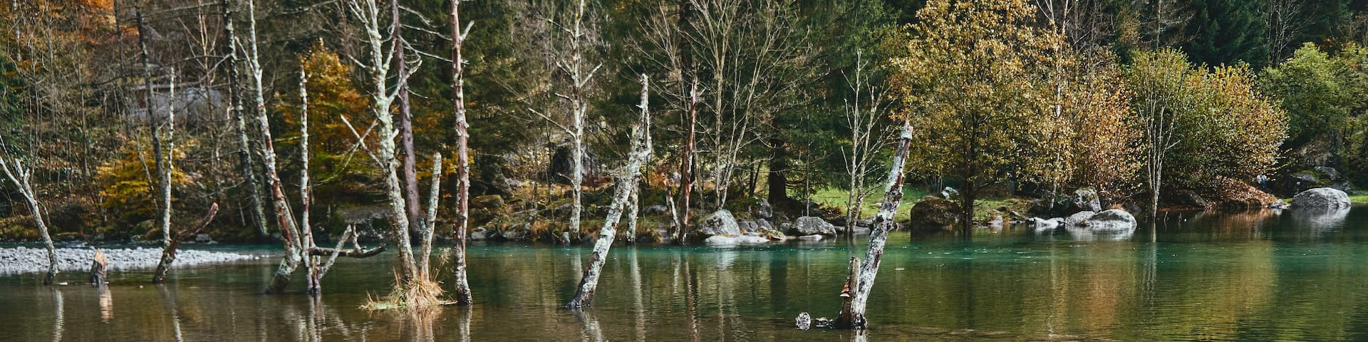 panorama view of small lake with reflections and multicolor woods, in autumn season lake in Val di Mello, Val Masino , Italy - lombardy.