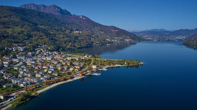 A lake surrounded by mountains and a town with houses and boats.