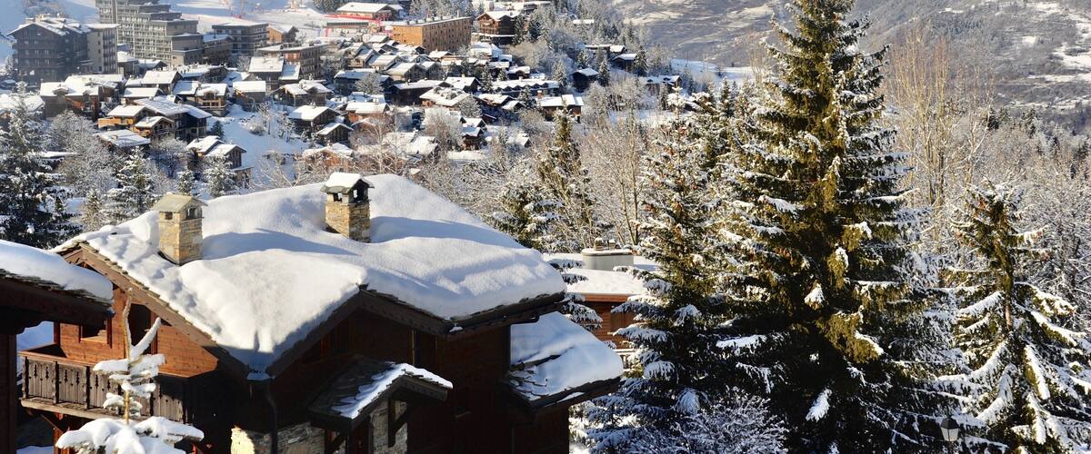 Courchevel 1550, Rhône Alps France, ski resort village in winter with wooden chalet and pine trees.