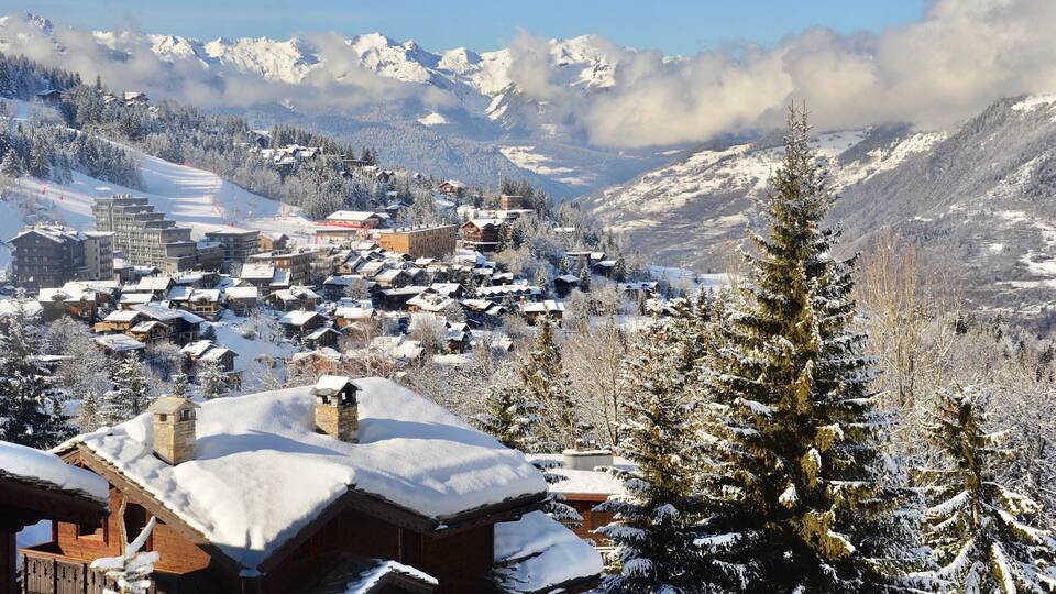 Courchevel 1550, Rhône Alps France, ski resort village in winter with wooden chalet and pine trees.