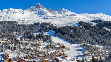 A snow-covered mountain with a ski resort and lodge buildings.