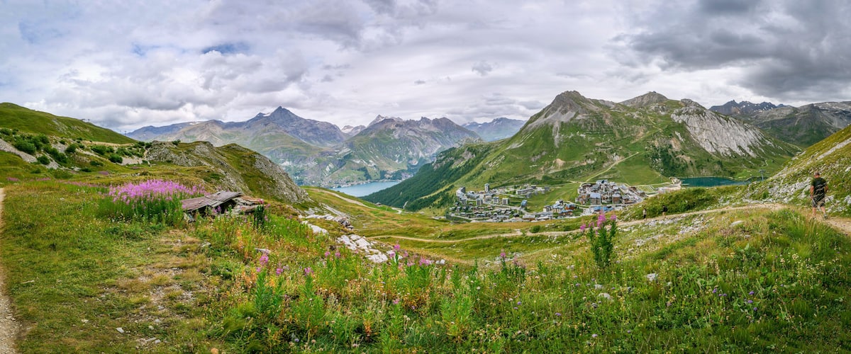 A mountainous landscape with a valley, a lake, and a small settlement.