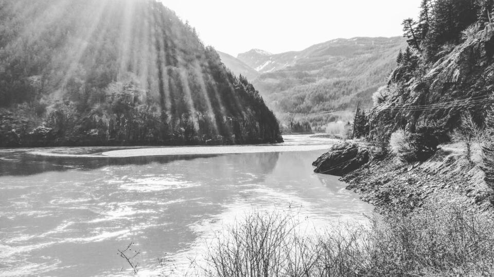 A river winding through a mountainous landscape with dense forests and rocky cliffs.