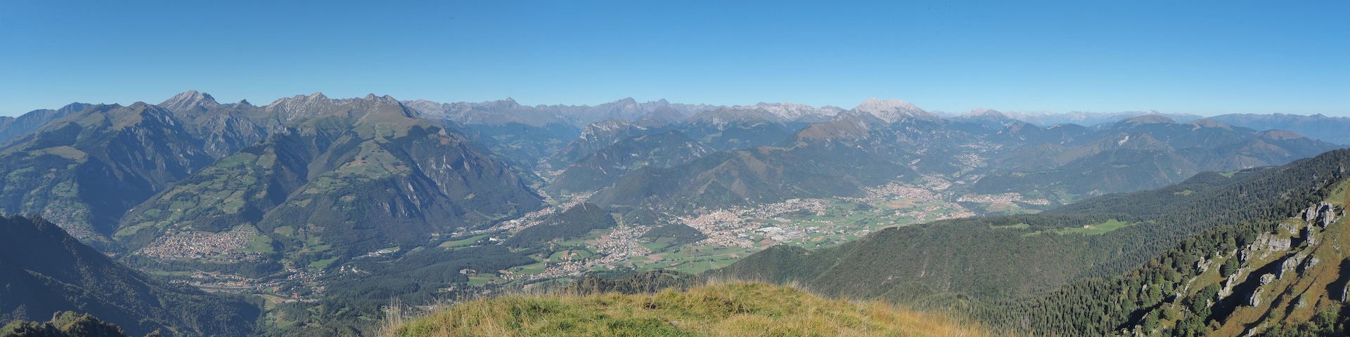 4K Drone aerial view to the Seriana valley and Orobie Alps in a clear and blue day. View of the highest mountains. Landscape from Pizzo Formico Mountain, Bergamo, Italy