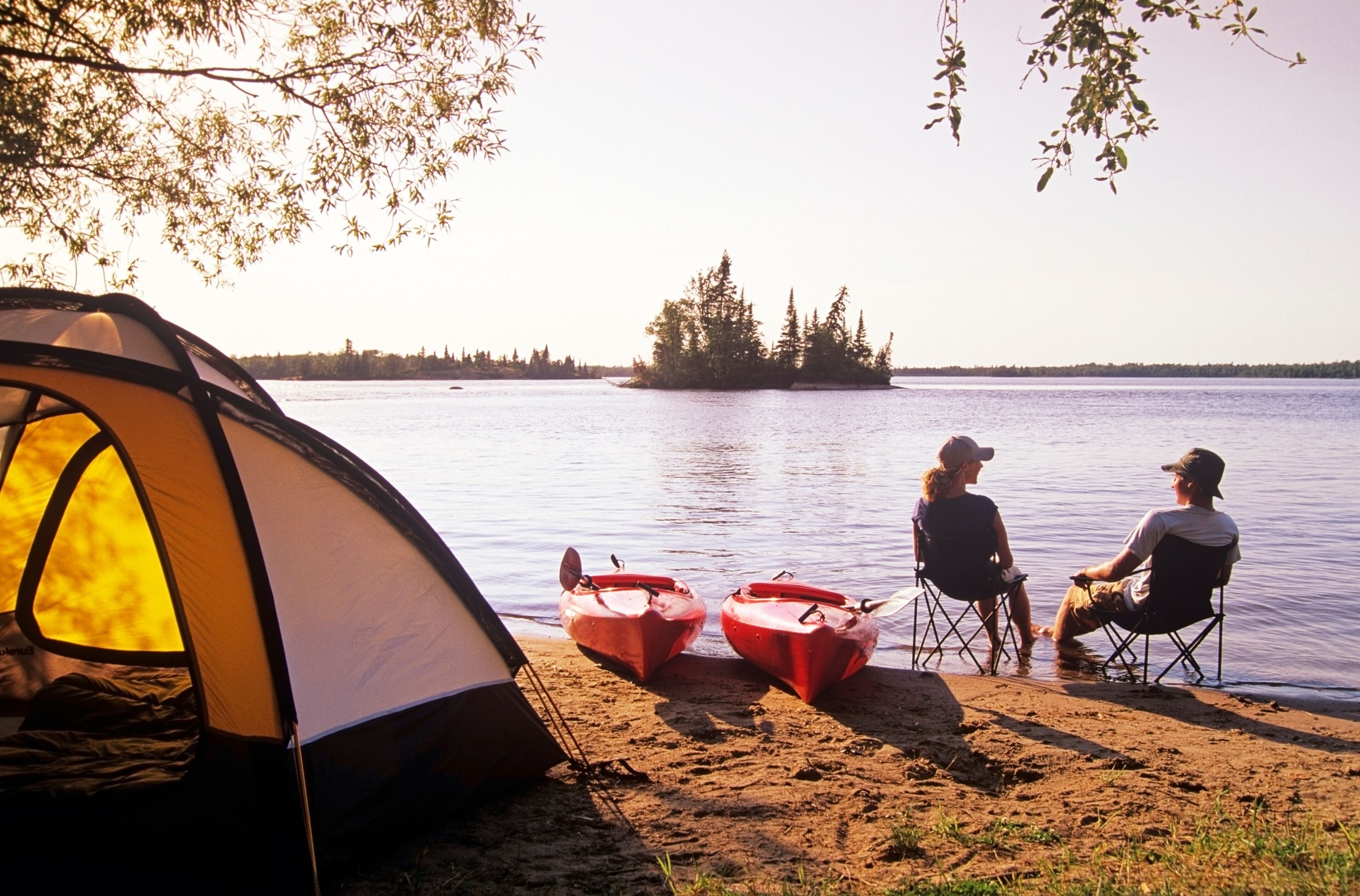 Couple relaxing at Otter Falls campground Whiteshell Provincial Park, Manitoba, Canada.