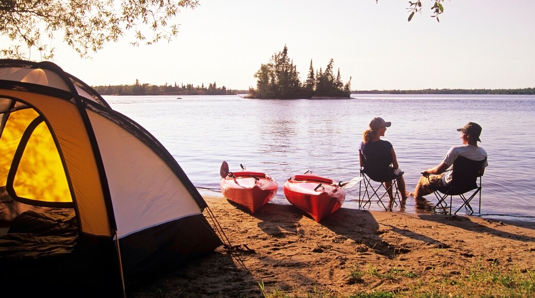 Couple relaxing at Otter Falls campground Whiteshell Provincial Park, Manitoba, Canada.
