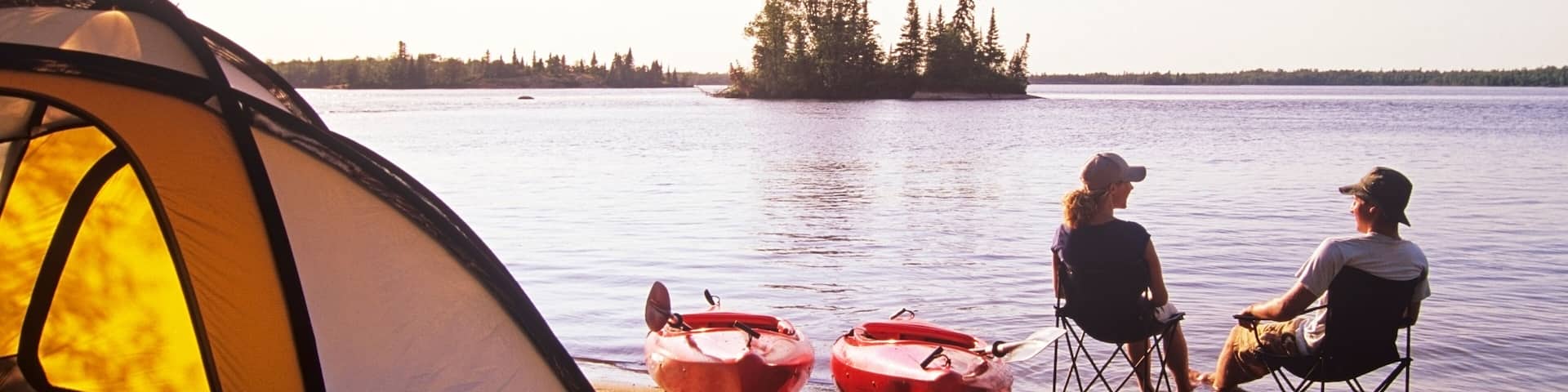 Couple relaxing at Otter Falls campground Whiteshell Provincial Park, Manitoba, Canada.