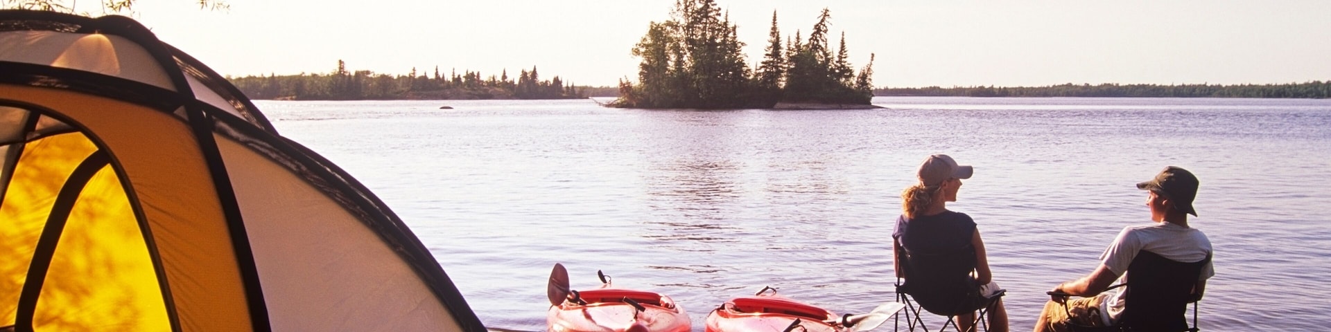 Couple relaxing at Otter Falls campground Whiteshell Provincial Park, Manitoba, Canada.