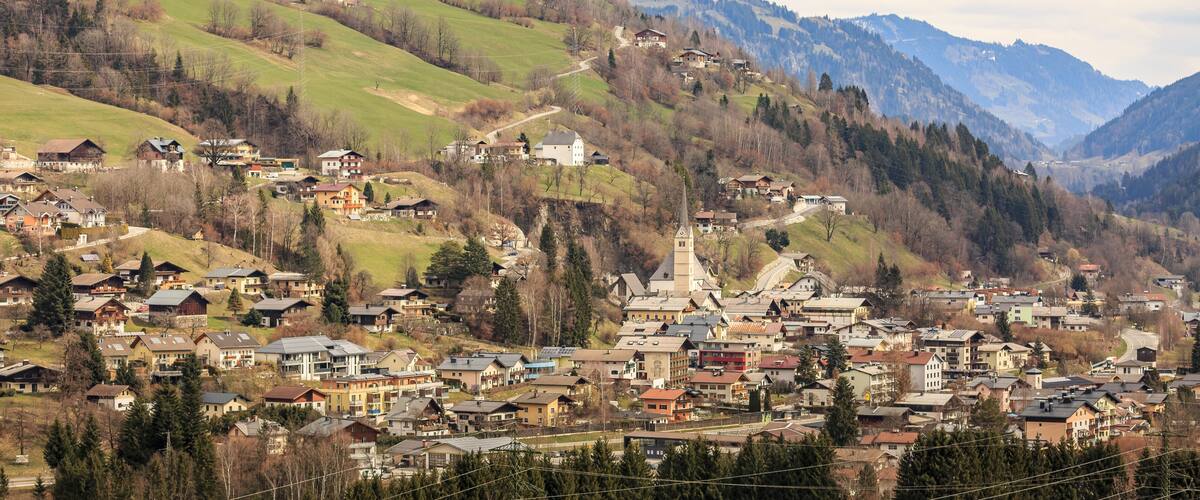 A mountainous town with houses, a church, and a winding road.