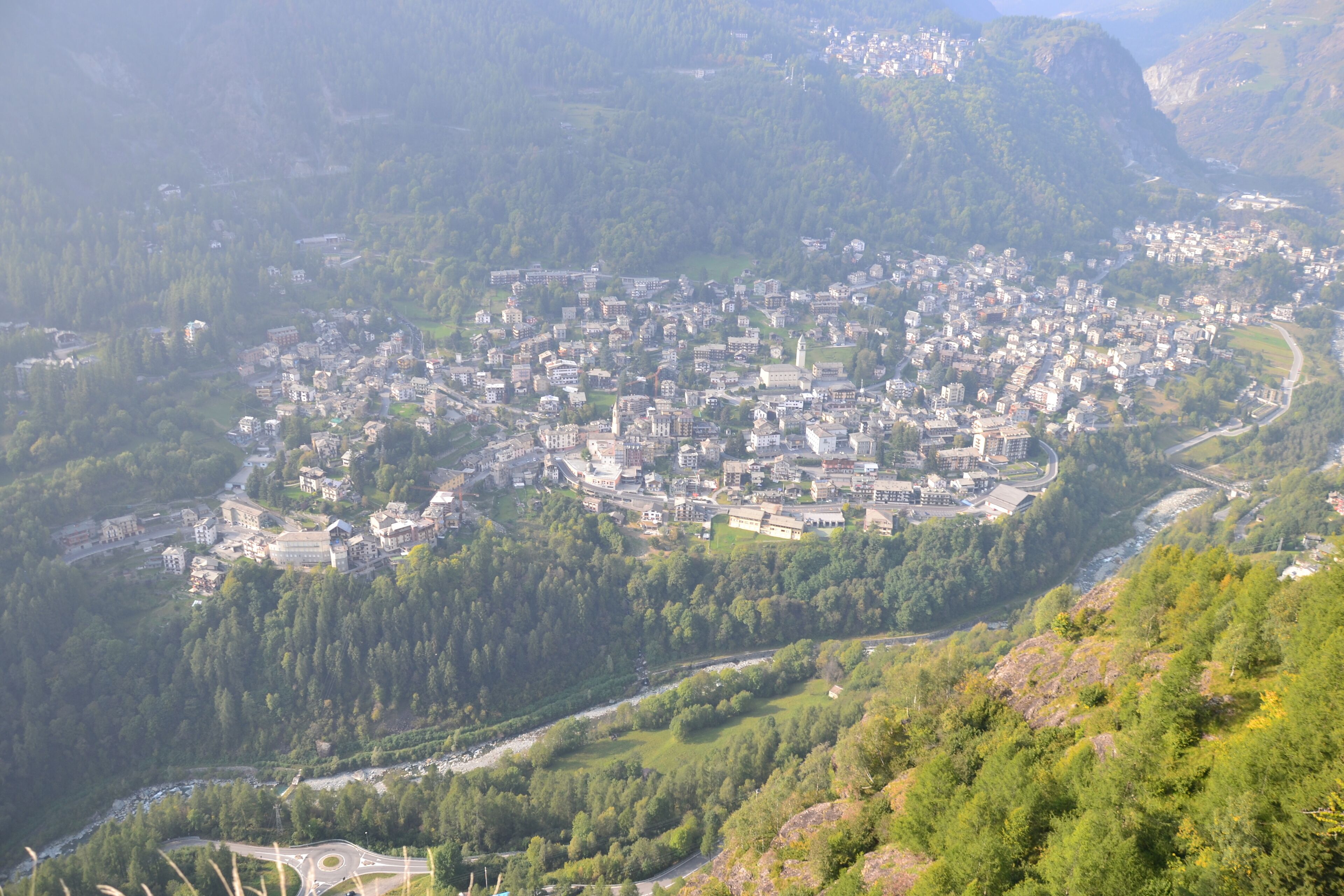 A town nestled in a valley surrounded by forested hills.