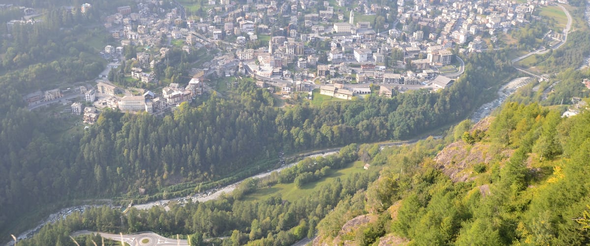 A town nestled in a valley surrounded by forested hills.