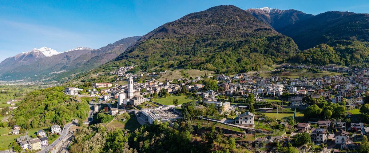 A town nestled in a valley with mountains in the background.