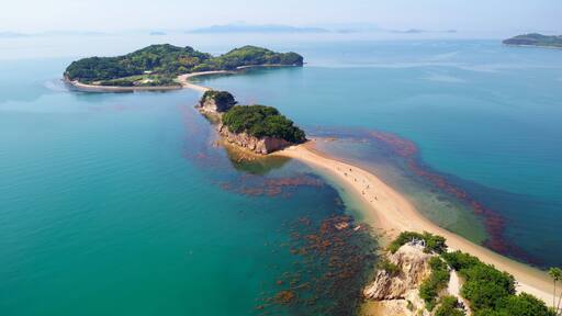 Aerial view of the Angel Road under blue sunny sky, a tidal sandbar connecting 3 beautiful offshore islets to Shodoshima Island in Seto Inland Sea and a tourist attraction in Tonosho, Kagawa, japan