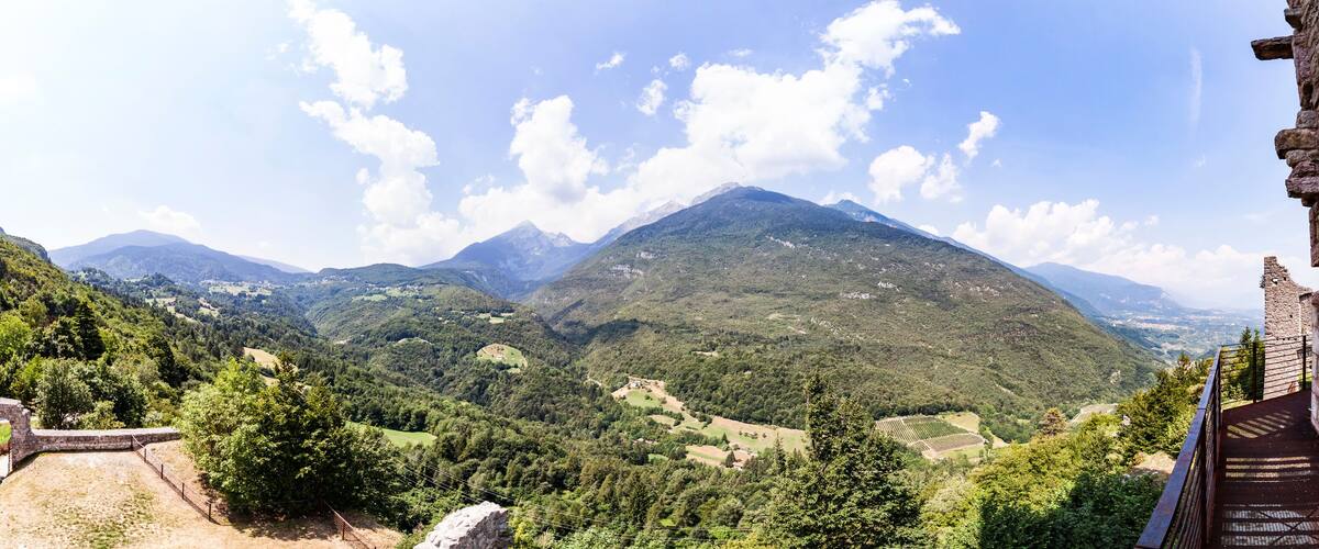 A mountainous landscape with a stone structure in the foreground.