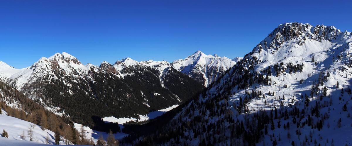 A snow-covered mountain range with a clear blue sky.